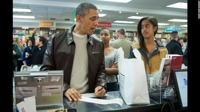 2013 оны арваннэгдүгээр сар. Вашингтон хотын “Politics & Prose” номын дэлгүүрээр Обама хоёр охины хамт хэсчээ.
