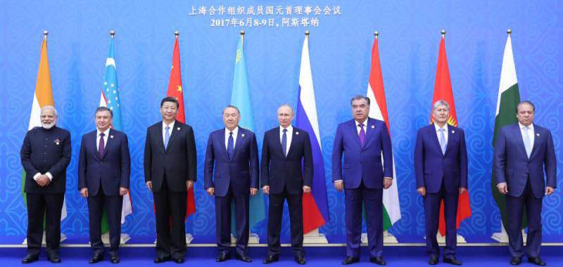 БНХАУ-ын дарга Си Зиньпин (зүүн гар талаасаа гурав дахь нь) ШХАБ-ын гишүүн бусад орны удирдагч, Энэтхэг болон Пакистаны Ерөнхий сайд нарын хамт. 2017 оны зургадугаар сарын 9-нд Казахстаны нийслэл Астана хотноо ШХАБ-ын гишүүн улс орнуудын Төрийн тэргүүнүүдийн зөвлөлийн 17 дахь удаагийн уулзалтын үеэр