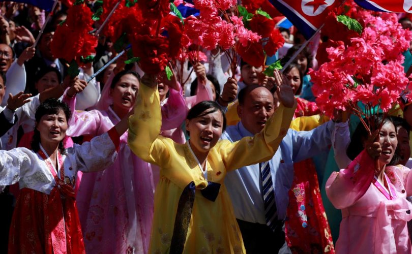 People wave plastic flowers during a military parade marking the 70th anniversary of North Korea's foundation in Pyongyang