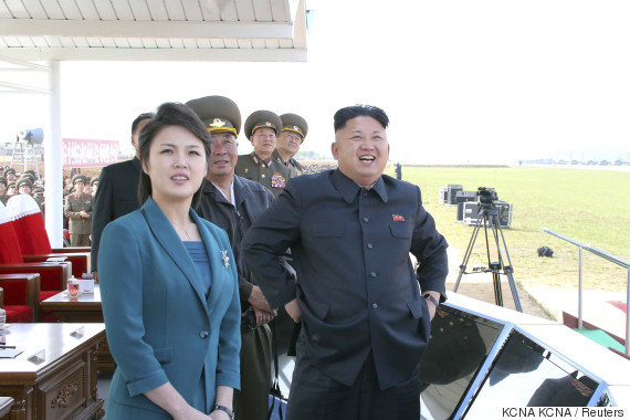 North Korean leader Kim stands next to his wife as they attend the 2014 Combat Flight Contest among commanding officers of the Korean People's Air Force